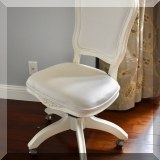 F28. Cream colored desk chair. 